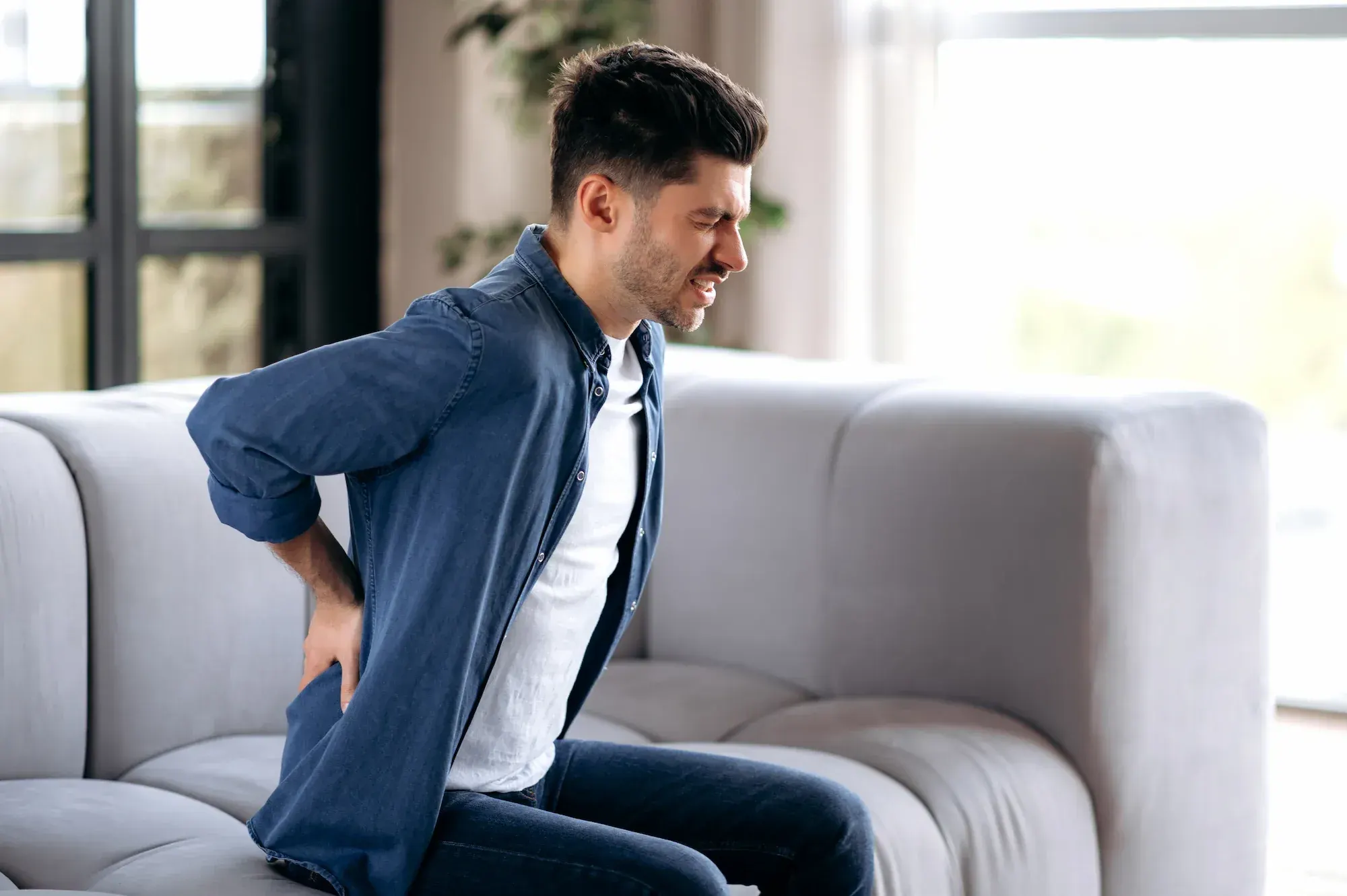 Person experiencing lower back and leg pain at Precision Chiropractic Rockford